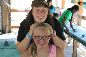 A counselor and a campers at Gold Arrow Camp in California, a summer camp, pose for a photo