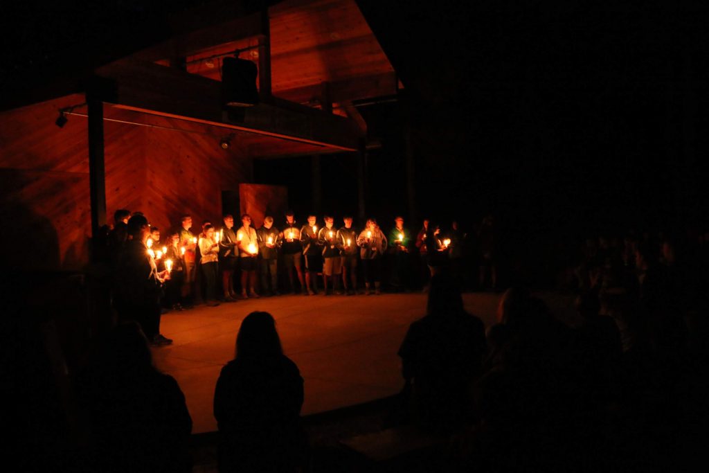 Counselors at Gold Arrow Camp, a summer camp in California, light candles to show their appreciation for their campers