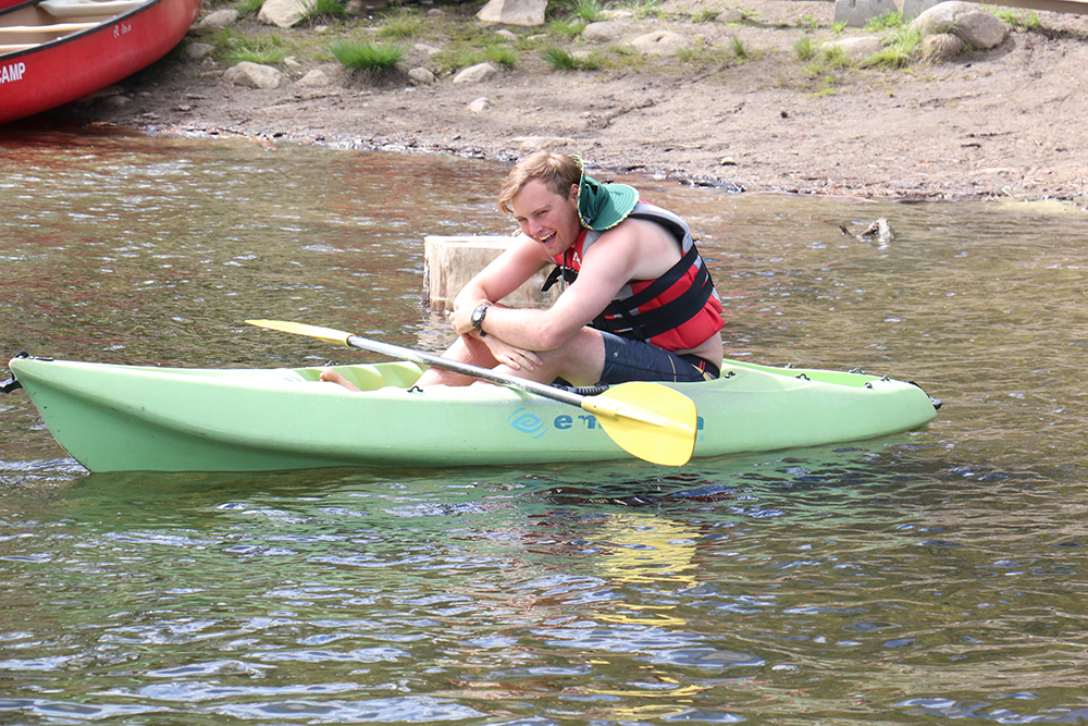 Simba, a summer camp counselor at Gold Arrow Camp, relaxes on a kayak. 