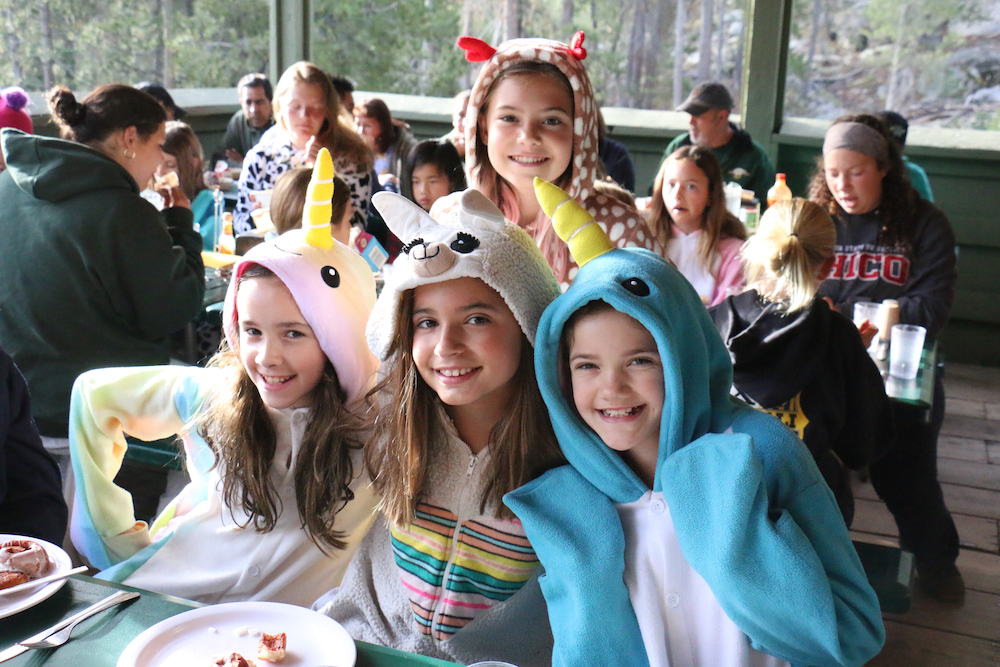 4 girls pose in their costume onesies. 