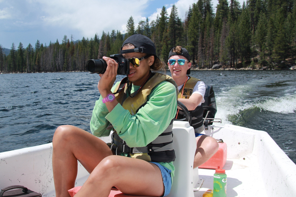 A photographer takes summer camp photos on a boat at a children's summer camp in California